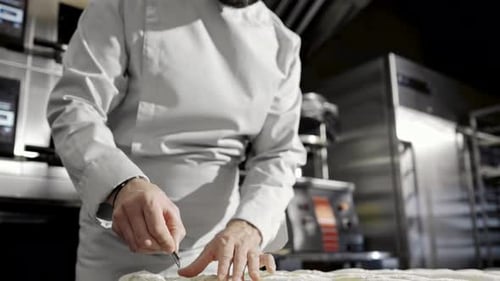 Close Up of Caucasian Man Cutting Dough with Razor While Working in Bakery Indoor Work of Baker