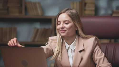 Young Woman Opening Laptop in Office Environment