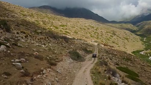 Drone: flies behind a car through a gorge in the mountains of Kyrgyzstan