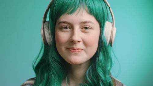 Videoporträt einer schönen jungen Frau der Generation Z, die lächelt und Musik mit Kopfhörern hört