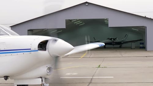 Einmotoriges Propellerflugzeug steht vor einem geschlossenen Flugzeughangar Transport für