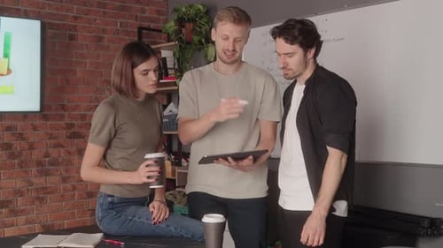 Business Team Collaborating on a Project Using a Tablet in a Modern Office