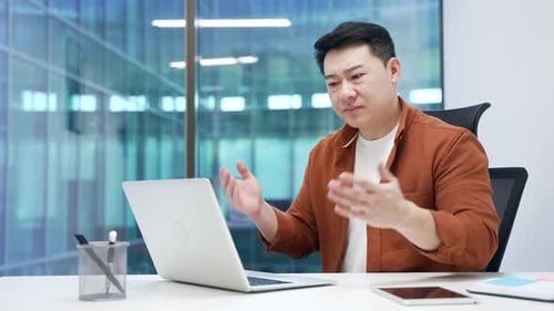 Frustrated Man Working at Computer in Modern Office