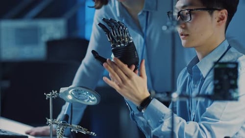 Technological Prosthetic Robot Arm is Tested by Two Professional Development Engineers in a High Te