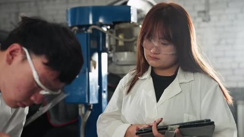 Professionals Recording Engine Measurements in Automotive Workshop