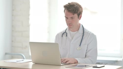 Junger Arzt arbeitet in der Klinik am Laptop