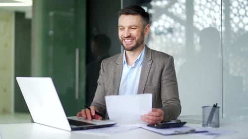 Man Works at Desk, Celebrates Achievement