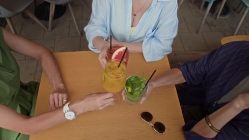 Femmes qui tintent des verres et sirotent des cocktails