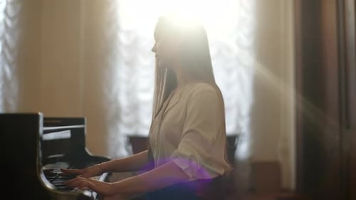 Side View of Talented Female Student Pianist with Long Hair Training Playing Classical Music on