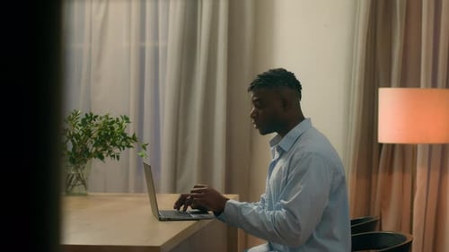 Young Adult Working on Laptop at Home