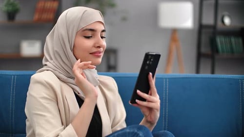 Woman Using Smartphone, Sitting on Couch Indoors