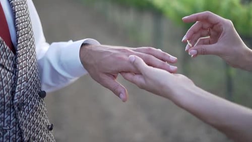 Nahaufnahme eines Verlobten, der die Hand seines Partners berührt und einen eleganten Diamantring enthüllt, eingefangen