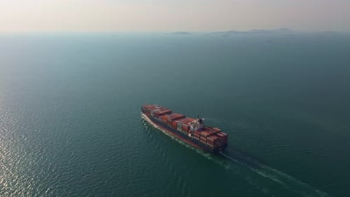 Trade vessel cutting through ocean waves, Thailand