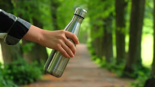 Closeup of Unrecognizable Female Hand Holding Water Bottle