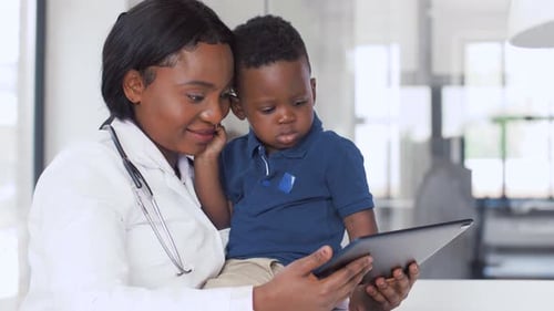 Doctor Showing Tablet to Child Patient in Office