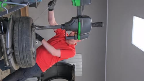 Porträt eines Mechanikers, der Autoräder repariert, Autoservice, Vertikales Video