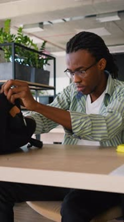 African American Student Packs Books After Class Ends