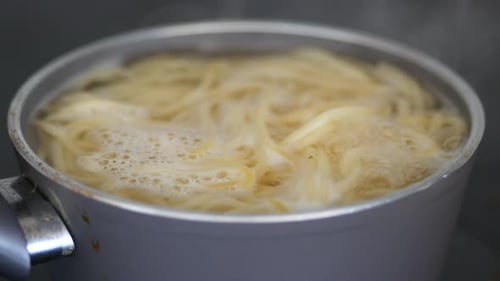 Detailed Picture Showing Spaghetti Noodles Boiling Ideal for Content Related to Cooking