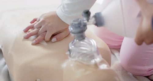 Hands Practicing CPR on Training Mannequin