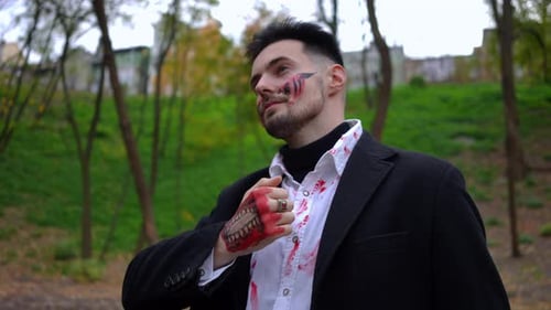 A Mysterious Figure Dressed in Blood Stained Attire Wanders Through a Dense Forest