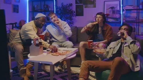 Four Diverse Students Enjoying Beer and Pizza and Chatting at Home Party