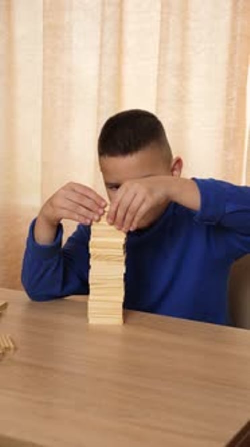 97Ein Junge spielt mit Holzwürfeln und baut verschiedene Formen.