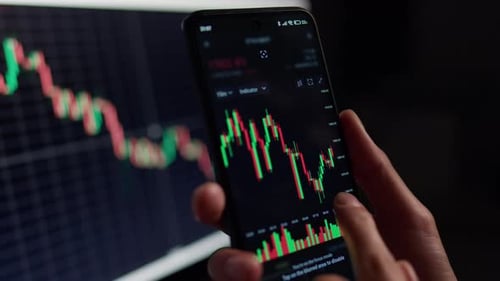 Hand Scans Stock Market Graph on Smartphone