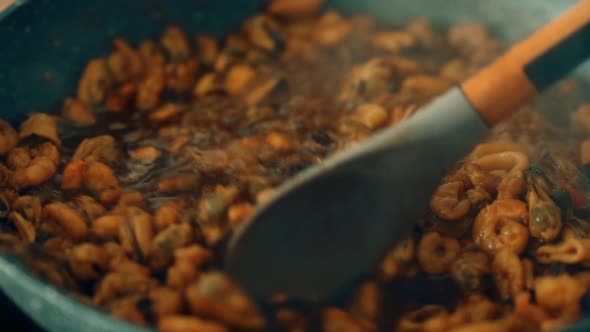 Stirring Seafood Mix in Rich Simmering Sauce Mixing Shrimp Mussels and ...