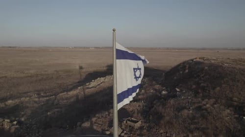 Israeli Flag Flies Over Barren Desert Landscape