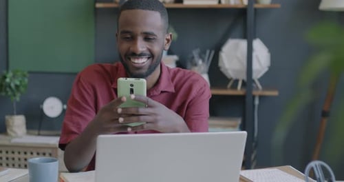 Man Enjoys Using Smartphone at Desk