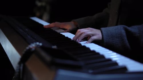 Hands Play Notes on Keyboard in Dark Setting