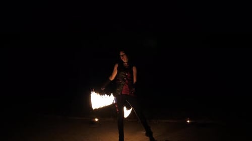 Fire Dancer Performing with Torches at Night