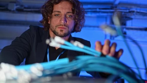 Man analysing cables in a data center
