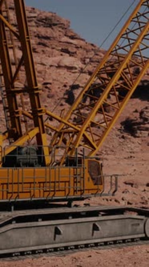 A Large Yellow Crane Sitting on Top of a Rocky Hillside