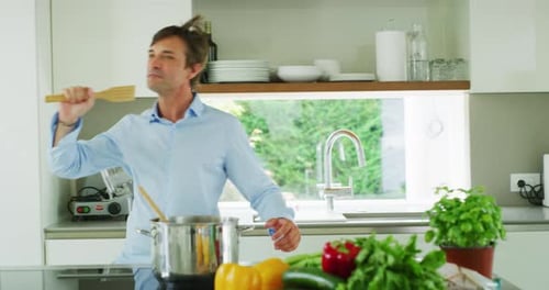 Happy Man Singing and Dancing in Kitchen