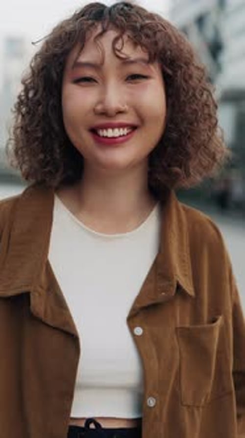 Vertical Video Portrait Of A Pretty Asian Girl Smiling While Standing On The Street And Looking At