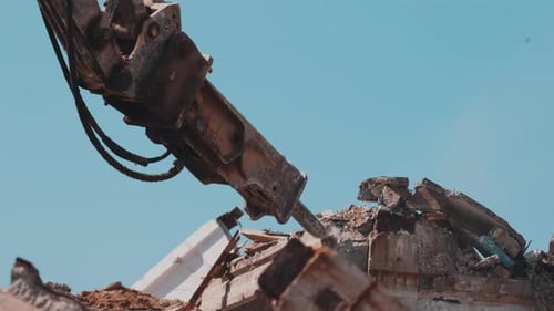 Excavator Hydraulic Hammer Breaking Concrete Rubble on Demolition Site Close Up