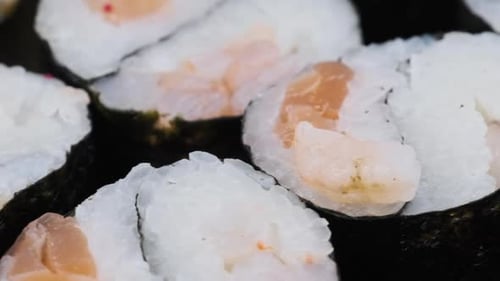 Japanese Sushi Rolls in Plastic Box is Rotating Closeup