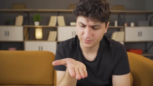Man Sitting Thinking and Picking at His Fingers