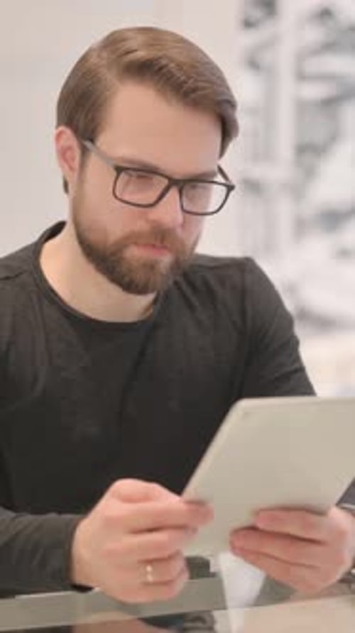 Adult Man Upset by Loss on Tablet, vertical