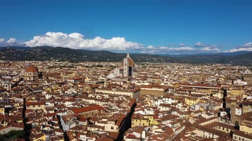 Drone flying fast to Cathedral of Santa Maria del Fiore and over city on a sunny day in Florence in