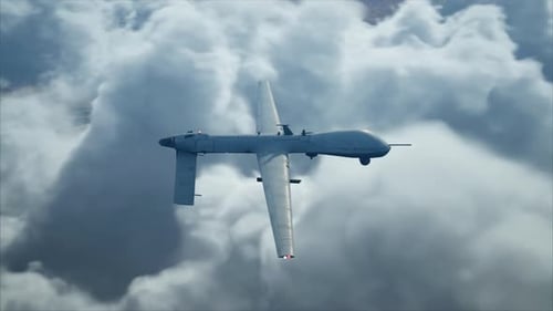 Military Drone Flying Over Desert Landscape Through Clouds