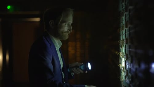 Man Opens Security Box in Dark Room