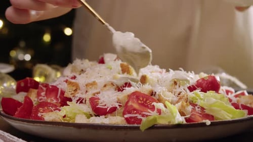 Sauce and Dressing Added to Large Bowl Containing Generous Portion of Caesar Salad Prepared for