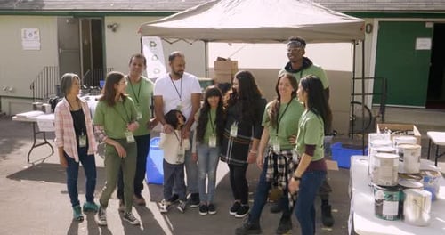 Portrait Happy Volunteers Recycling in Sunny Parking Lot Affectionate