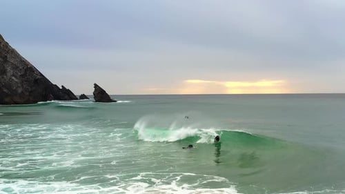 Unidentified Surfers Bodyboarder Surfing Ocean Wave at Sunset
