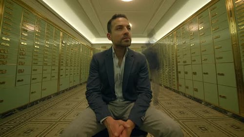 Businessman Sitting Inside Bank Safe Vault Room Watching People