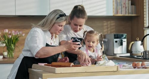 Glückliche Familie Junge Mutter Ältere Großmutter und Schulkinder lernen, wie man Koch backt