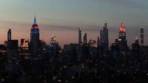 Illumination en soirée des gratte-ciel emblématiques de New York en hommage à l'Empire State Building et à One World