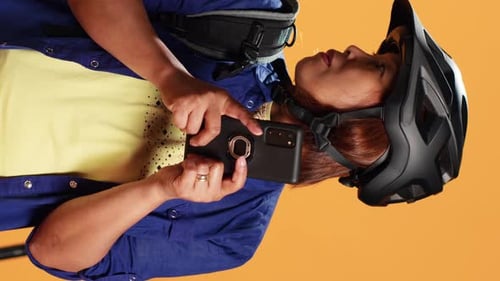 Woman With Bike Helmet Uses Smartphone